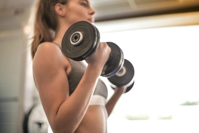 A woman focused on strength training with a dumbbell, avoiding the cardio-only fat loss mistake.