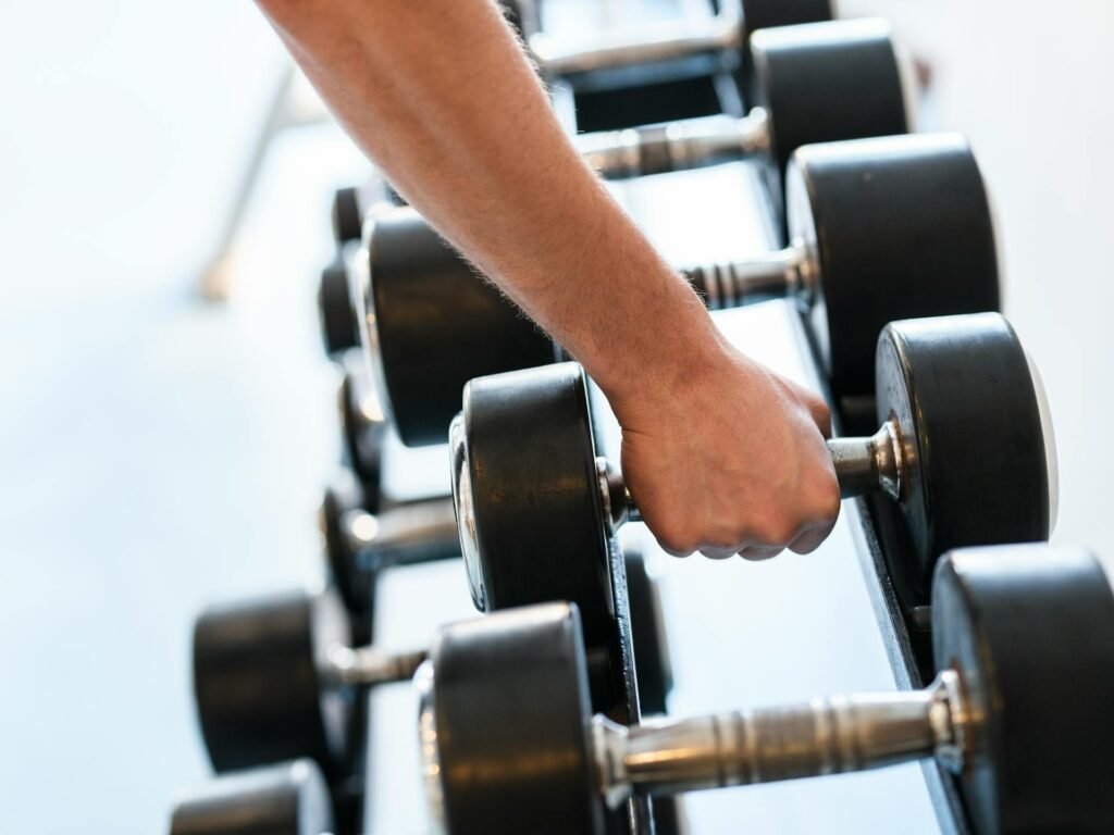 A rack of dumbbells of increasing weight, illustrating the concept of progressive overload in strength training.